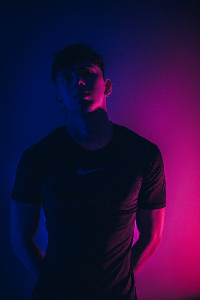 Confident man in dark room with neon light